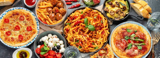 Italian food assortment on dark background. Italian food assortment on dark background. Traditional food concept. Dishes and appetizers of indeed cuisine. Flat lay, top view, panorama italian food stock pictures, royalty-free photos & images