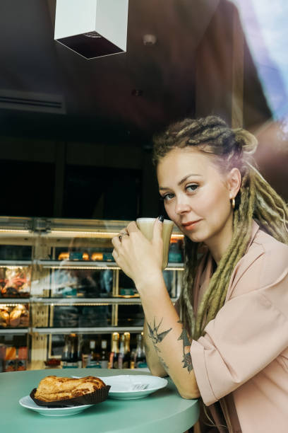 istock Caucasian woman with dreadlocks sitting in cafe. 1404001440