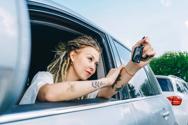 istock Happy smiling woman with car key. Driving 1404001443