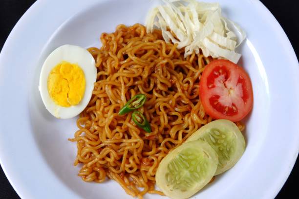 istock Fried instant noodles with egg and vegetables isolated on black background 1404001643