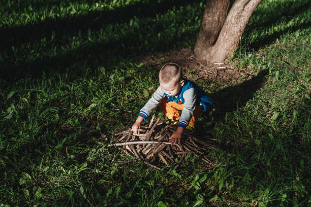 istock boy collect sticks in the park to play 1404001756