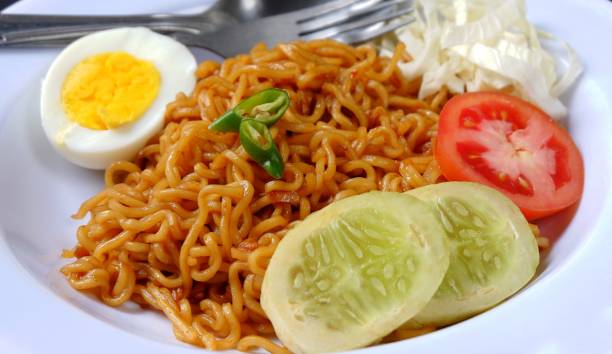 istock Fried instant noodles with egg and vegetables isolated on black background 1404002518