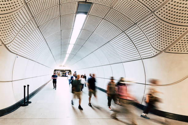 London, UK - 16 June, 2022: blurred motion of commuters traveling amid the modern futuristic architecture of the newly unveiled Elizabeth line on the London Underground transport network.