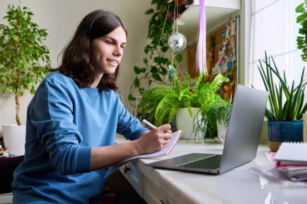 istock Teenage male student studying at home using a laptop 1404004273