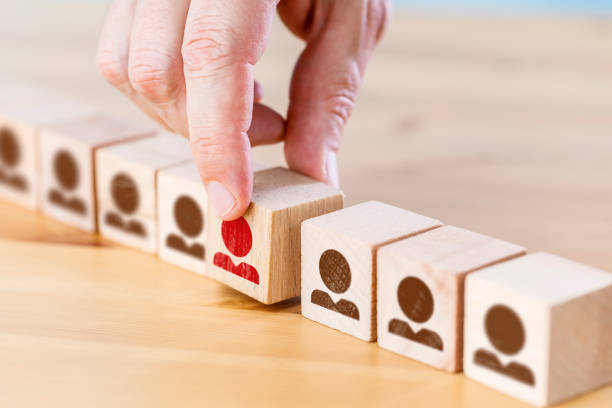 istock Person icon on wooden cube with hand picked different from the crowd 1404004604
