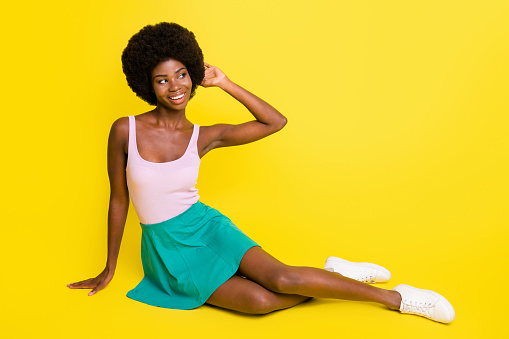 Full size photo of young happy positive cheerful afro girl smiling look copyspace isolated on yellow color background.