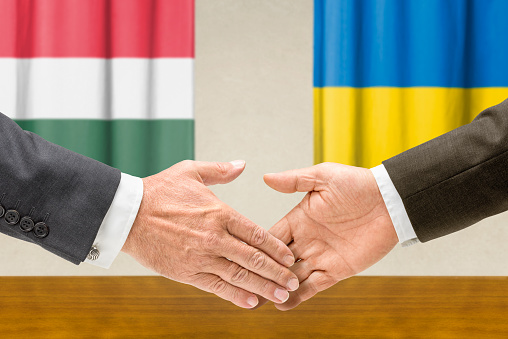 Officials of foreign countries shaking hands, French and EU flags up front