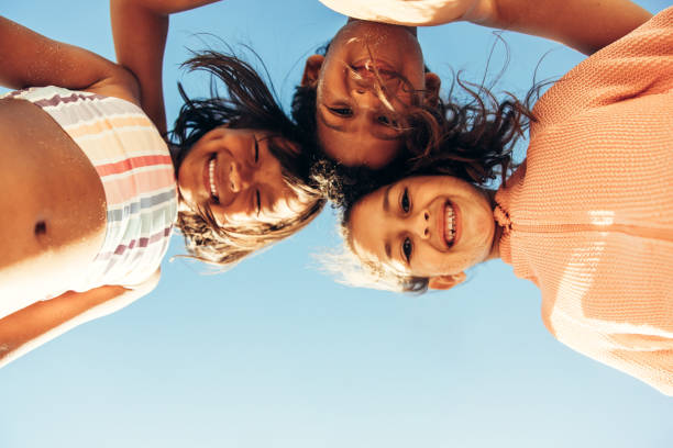 istock Low angle view of kids smiling happily at the beach 1404005455