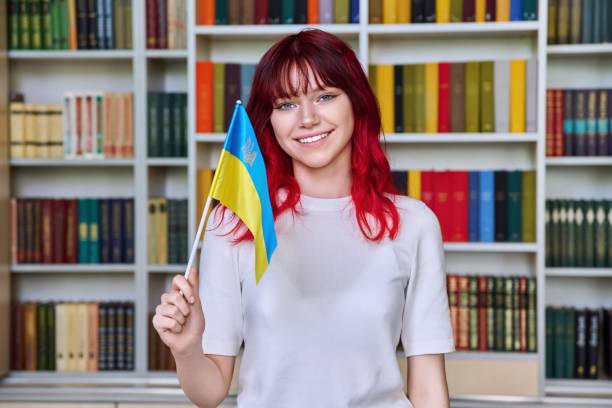 Teenage female student with flag of Ukraine in the library stock photo