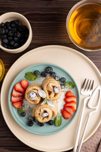 istock Thin pancakes, rolled into tubes, strewn with berries 1404005755