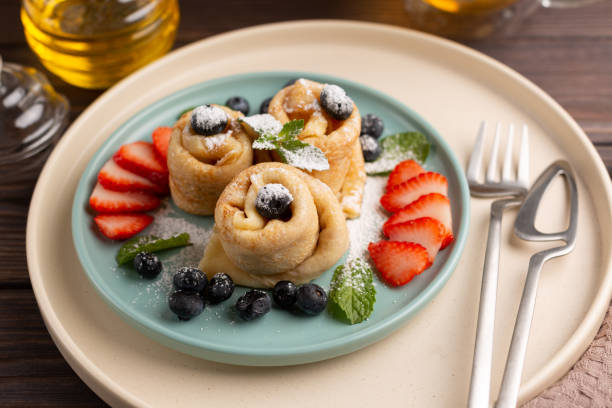 istock Thin pancakes, rolled into tubes, strewn with berries 1404005758