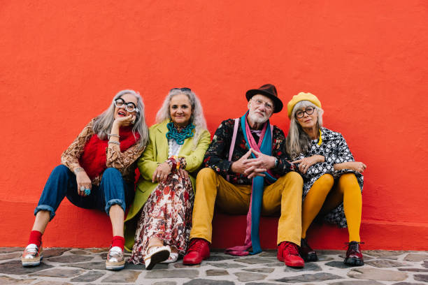istock Group of senior citizens sitting against a red wall 1404005913