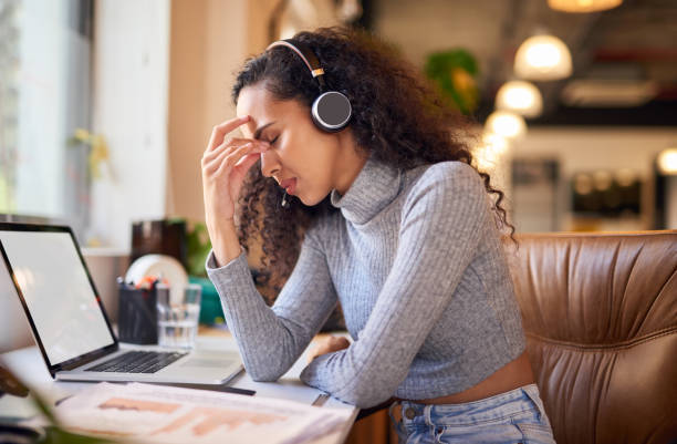 istock Male consultant looking stressed while working in a call centre. Female worker sitting in front of a laptop at her desk with a serious, thinking expression 1404006071