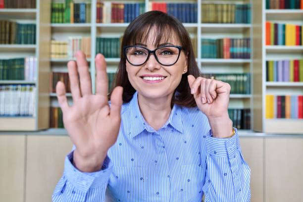 istock Female teacher in the library talking looking at the webcam, close-up face 1404006119