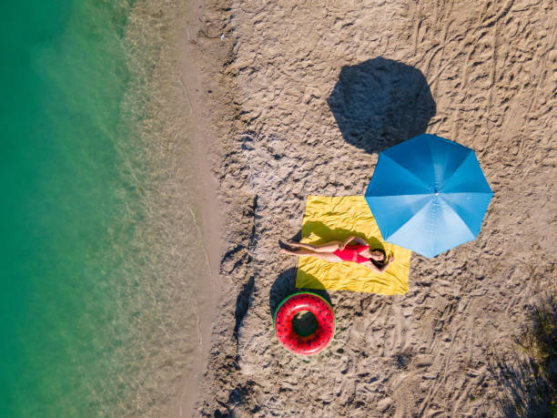 istock overhead view woman sunbathing at sandy beach 1404007984
