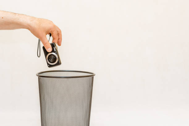 istock The broken digital camera is thrown into the trash for recycling.White,gray background,selective focus,copy space. 1404014161
