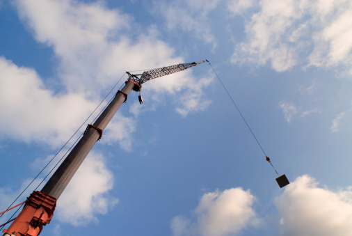 Construction crane lifting a heavy steel panel