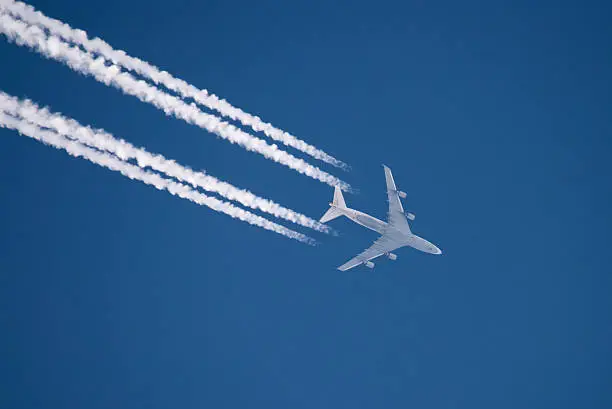 Airplane flying in high altitude leaving contrails. Photo taken in Duesseldorf, Germany. Distance is approx. 33000ft / 10000m.