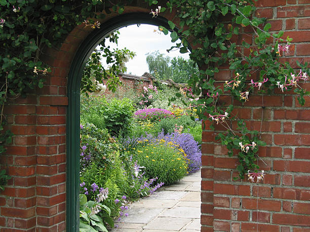 Entrance to the Garden An old brick archway reveals the garden behind foxglove photos stock pictures, royalty-free photos & images