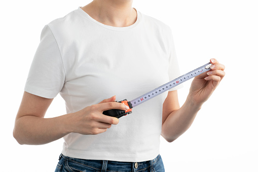 Close up image of woman holding measuring tape on white background