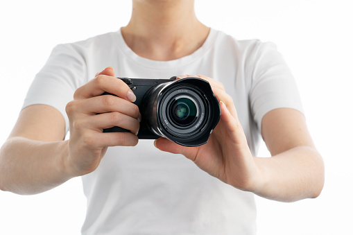 A close up image of woman holding digital camera in hands isolated white background