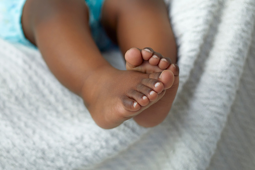 Closeup of baby feet resting on the sofa