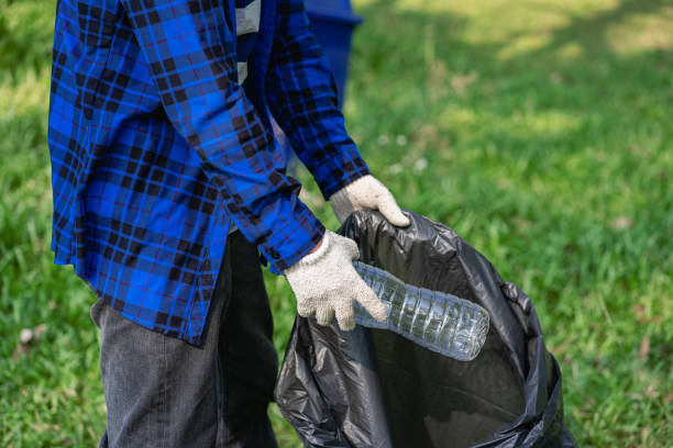 istock A man's hand puts plastic bottles in a black garbage bag to clean in the park. avoid pollution It is environmentally friendly and ecologically clean on Earth Day and can be sold for free income. 1404021349