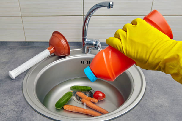 the hand of a person in yellow protective gloves holds a plumbing cleaner - sink drain plumber domestic kitchen imagens e fotografias de stock