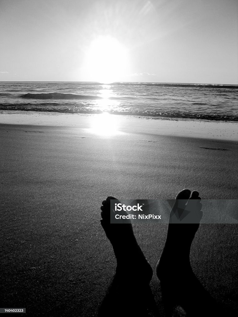 Feet in paradise Sitting on the beach  Arranging Stock Photo