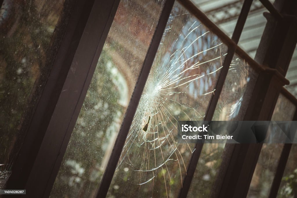 Zerbrochene Glasscheibe Broken glass pane in an old greenhouse Color Image Stock Photo