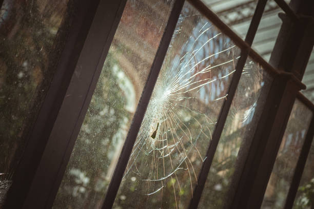 Zerbrochene Glasscheibe Broken glass pane in an old greenhouse gebrochen stock pictures, royalty-free photos & images
