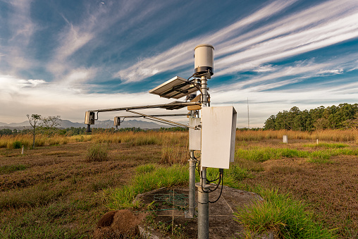 Field weather station. Equipment for agriculture and precision industry. Blue sky with clouds.