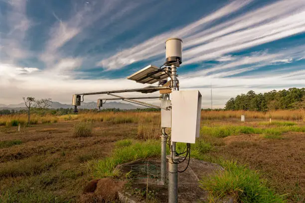 Field weather station. Equipment for agriculture and precision industry. Blue sky with clouds.