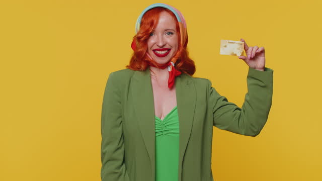 Redhead girl show plastic credit bank card advertising transferring money cashless online shopping