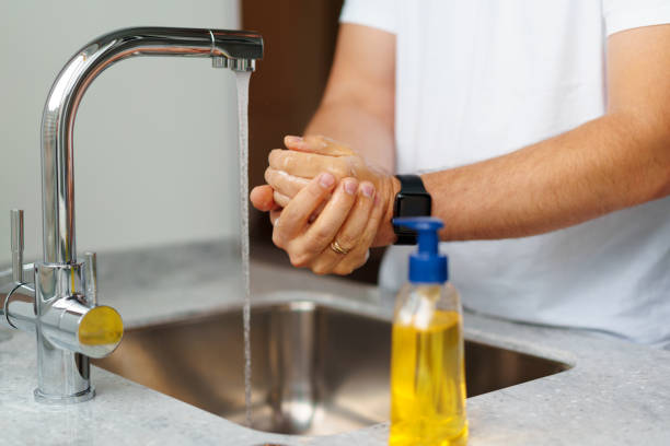 istock Man washing hands with soap in a sink at his home 1404034546