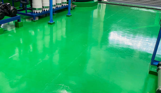 The concrete floor is covered with green epoxy in the factory where the steel platform for the machines is placed. stock photo