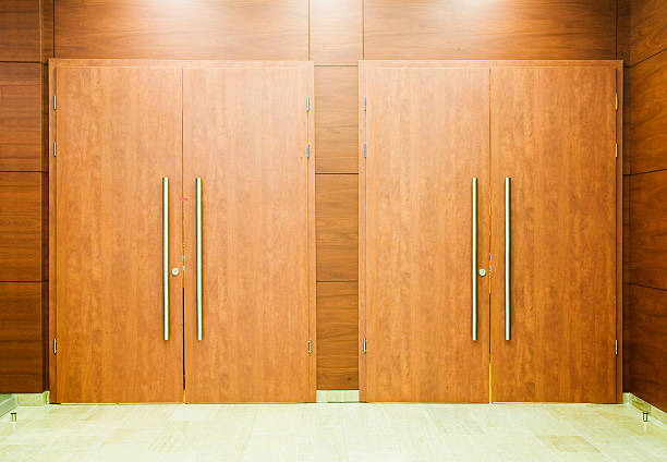 istock Two wooden doors side by side with long metallic handles 140403997