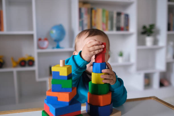 istock New boy playing with multi colored wooden block toys 1404040283