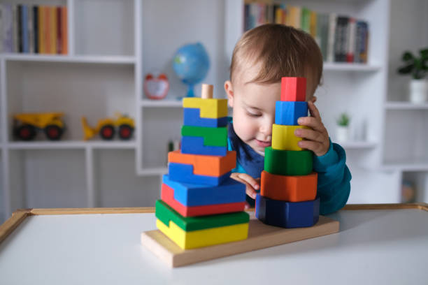 istock New boy playing with multi colored wooden block toys 1404040898