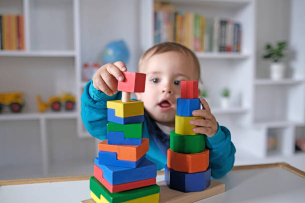 istock New boy playing with multi colored wooden block toys 1404040900