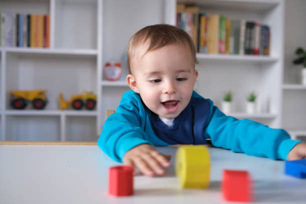 istock New boy playing with multi colored wooden block toys 1404040906