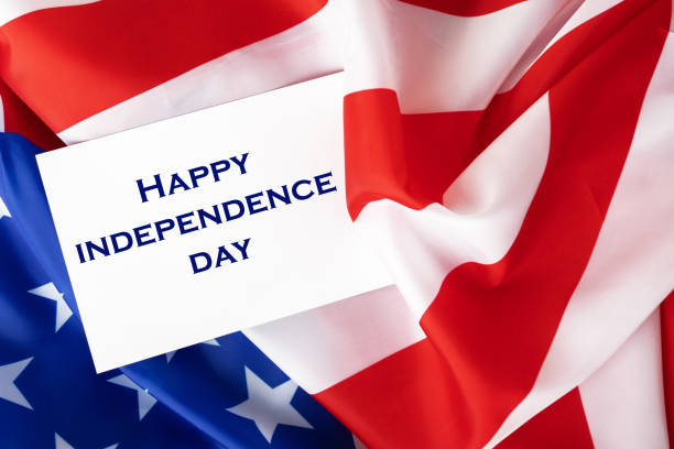 istock happy independence day, white card on american flag 1404041292