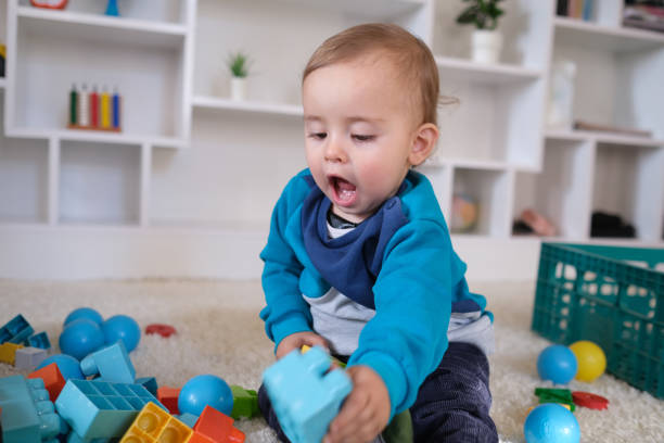 istock New boy playing with multi colored wooden block toys 1404041322