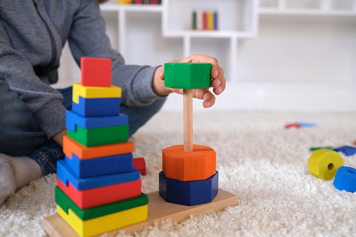 playing with multi colored wooden block toys