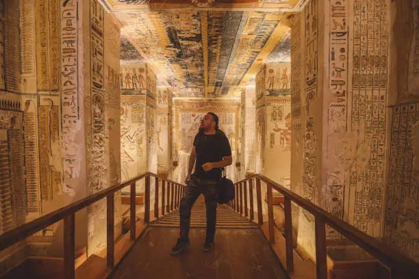 White Man Tourist inside of the Pharaoh tomb in the Valley of the Kings in Luxor, Egypt