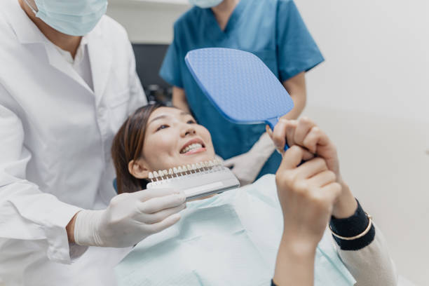 Medical care - Asian female patient in consultation with her dentist for her teeth whitening procedure Medical care - Asian female patient in consultation with her dentist for her teeth whitening procedure dental crown stock pictures, royalty-free photos & images