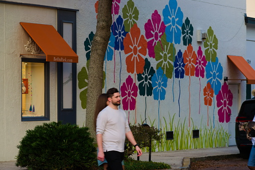 Winter Park, Florida, Dec 18, 2021: people walk by the building with beautiful mural.