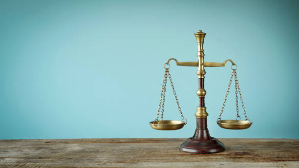 Scales of justice on the wooden table stock photo