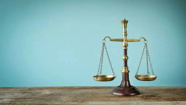 Photo of Scales of justice on the wooden table