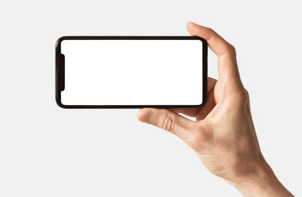 Male hand showing smartphone with white blank screen mock-up, isolated on grey background stock photo